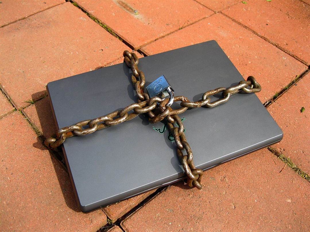 Laptop yang terkunci dengan rantai pengaman berwarna kuning