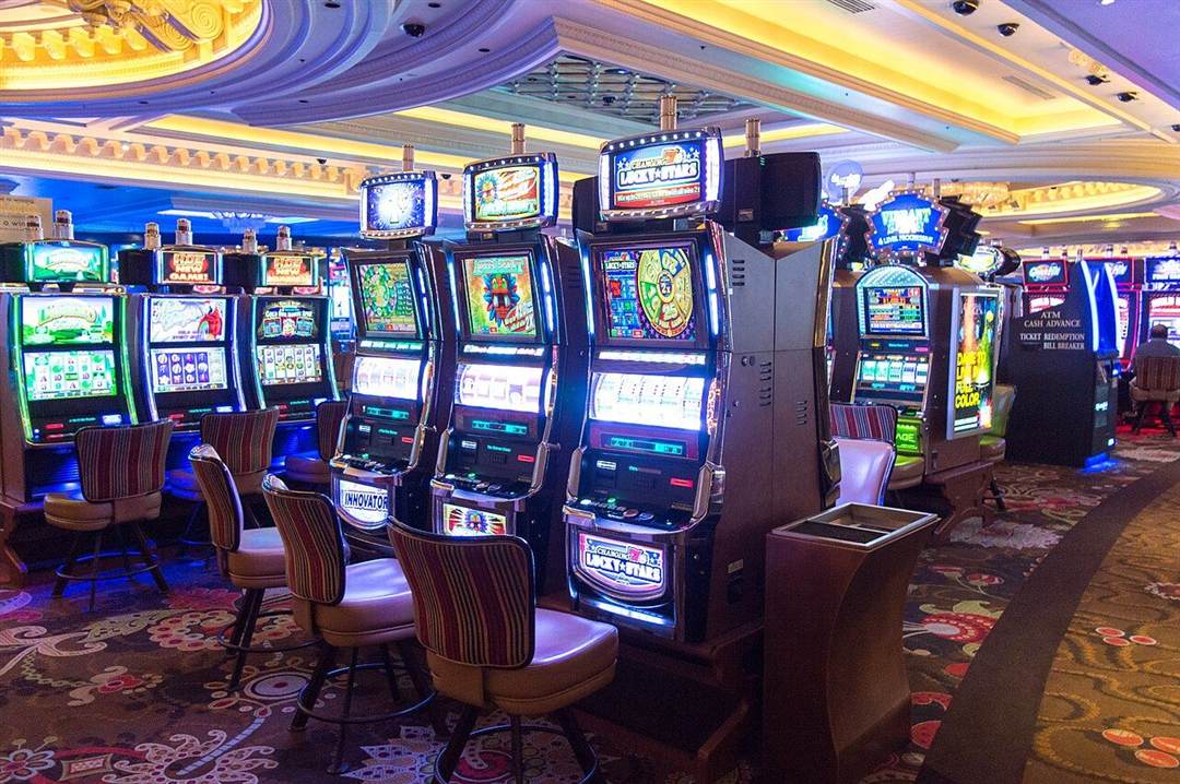 Barisan mesin slot dengan lampu warna-warni di sebuah casino